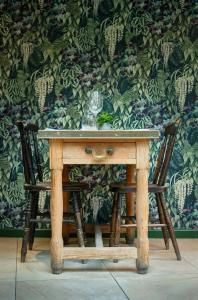 a wooden table with two chairs and a wine glass at The Westleton Crown in Westleton