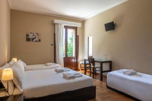 a hotel room with two beds and a table and chair at Il Lavatoio Dimora Storica in Castel di Sangro