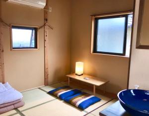 Guest House Kamakura Zen-ji في كاماكورا: حمام مع طاولة ومصباح ومغسلة