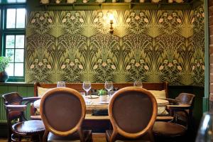 a dining room with a table and chairs and a wallpaper at The Westleton Crown in Westleton