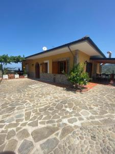 a house with a large stone patio in front of it at B & B Il Campanile in Perdifumo