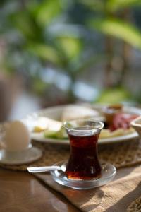 een kopje thee op een tafel met borden eten bij Gulluk Life Hotel in Gulluk