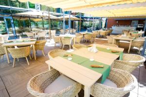 a restaurant with tables and chairs and windows at Pleiada Boutique Hotel & Spa in Iaşi