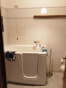 El baño incluye bañera blanca con lavamanos. en lago dorato, en Dervio