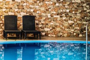 two black chairs sitting next to a swimming pool at Interhotel America in Písek