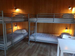 a room with three bunk beds and a table at Gröna Uddens Camping in Mariehamn +19 photos