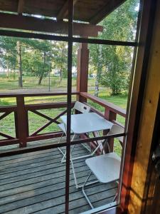 un porche con una mesa blanca y sillas. en Gröna Uddens Camping en Mariehamn