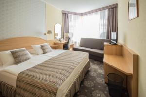 una camera d'albergo con letto e divano di Hotel Orion Várkert a Budapest