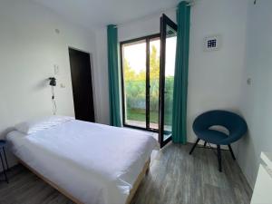 um quarto com uma cama, uma cadeira e uma janela em Sea You Guest House em Ezerets