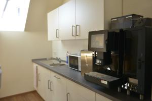 a kitchen with a counter with a microwave and a sink at Gästehaus Rothert in Bramsche