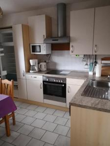 a kitchen with white cabinets and a stove top oven at Anton Schuler in Niedenstein