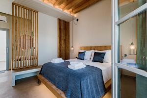 Lindos Calmare Suites في ليندوس: غرفة نوم عليها سرير وفوط