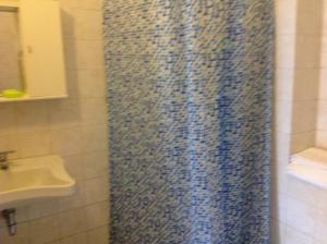 cortina de ducha en el baño con lavamanos en Le Copertelle Bed & Breakfast, en Serra San Quirico