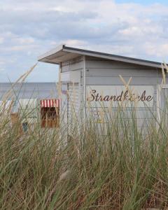 霍瓦赫特的住宿－❤️ KLEINE AUSZEIT ❤️，海滩上一座小建筑,用词标准我