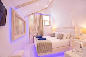 a white bedroom with a bed and a couch at Rhodos Horizon Blu-Adults Only in Rhodes Town