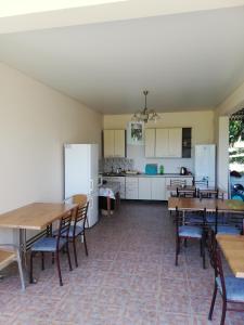Aparthotel na Abovyana 7 في نوفي أفون: مطبخ وغرفة طعام مع طاولات وكراسي خشبية