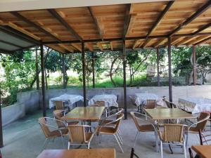 un patio al aire libre con mesas, sillas y árboles en Aparthotel na Abovyana 7, en Novi Afon