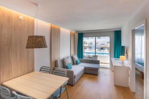 a living room with a table and a couch at Cabot Hobby Club Apartments in Port de Pollensa