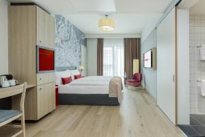 a hotel room with a bed and a bathroom at IntercityHotel Saarbrücken in Saarbrücken
