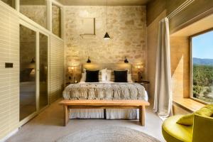 a bedroom with a bed and a large window at Torre del Marqués Hotel Spa & Winery - Small Luxury Hotels in Monroyo