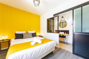 um quarto amarelo com uma cama e uma secretária em Le Black & Yellow - Appart'Hôtel SPA - Clim - Melina & Alfred Agen em Agen