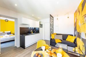 uma sala de estar com um sofá e uma mesa em Le Black & Yellow - Appart'Hôtel SPA - Clim - Melina & Alfred Agen em Agen