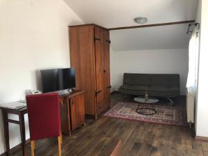 a living room with a couch and a television at Hotel Lug in Osijek