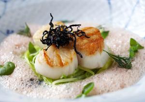 un plato de comida con camarones encima de la lechuga en Fladbro Kro, en Randers