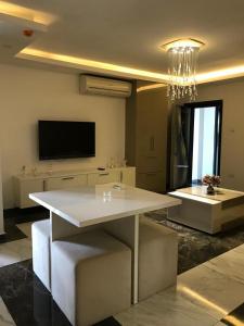 a living room with a white table and a tv at Aquamarine Luxury Residence in Kyrenia