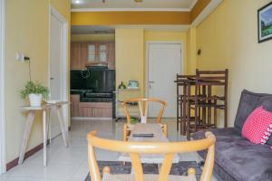 a living room with a couch and a table at Tidy 2BR Apartment at Silkwood Residences near BINUS By Travelio in Tangerang