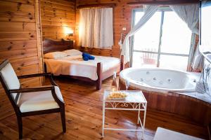a bedroom with a bed and a tub in a room at Morad Haharbel - Boutique Resort in Arbel