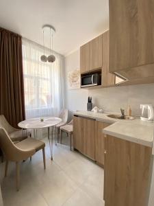 a kitchen with a table and chairs and a sink at Homelike Apartment in Lviv