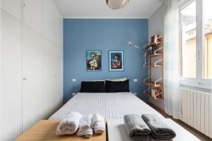 フィレンツェにあるSan Remigio Viewの青い壁のベッドルーム1室、ベッド1台(タオル付)
