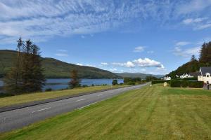 una carretera junto a un cuerpo de agua y un lago en Conaglen, Glenloch View, Fort William 2-Bedroom Loch Side Flat en Fort William