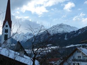 a church with a view of a snow covered mountain at Haus Driendl in Mieders