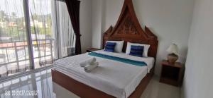 a bedroom with a bed with a stuffed animal on it at Sure Guesthouse in Kamala Beach