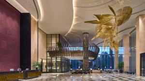 hol ze złotymi żyrandolami w budynku w obiekcie InterContinental Hefei, an IHG Hotel w mieście Hefei