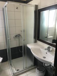 a bathroom with a shower and a sink and a mirror at Saint Amon Hotel in Faliraki