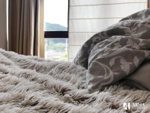 um cobertor num sofá com um tapete branco em Apartamentos Arha em Potes