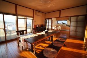 太宰苑 - Dazaien Traditional Japanese houses في دازايفو: غرفة معيشة مع طاولة طعام ومطبخ