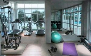 a gym with treadmills and exercise equipment in a building at Grandblue condominium 106,302 in Mae Pim