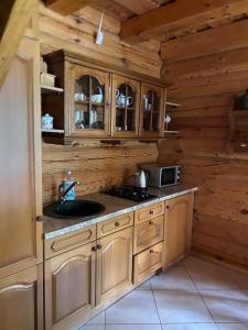 a kitchen with wooden cabinets and a sink in a cabin at Šeimyninis namelis nr.1 in Kurėnai +9 photos