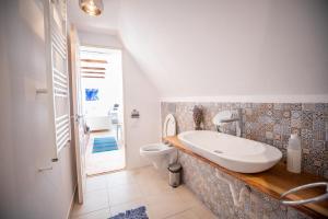 um banheiro com pia e vaso sanitário em Casa Paulini em Cisnadioara mais 53 fotografias