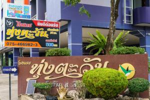 a sign in front of a building with bushes at Thungtawan Hotel in Nakhon Si Thammarat