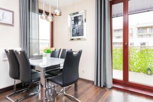 a dining room with a table and black chairs at Apartments Gdańsk Drzewieckiego by Renters in Gdańsk