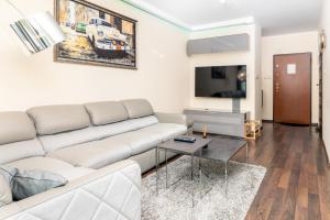 a living room with a couch and a flat screen tv at Apartments Gdańsk Drzewieckiego by Renters in Gdańsk