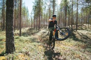 a man riding a bike through a forest at Finlandia Hotel Airport Oulu in Kempele