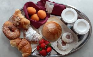 a tray filled with different types of pastries and strawberries at Via Pezza 100 in Ragusa