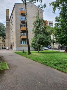 un edificio con un árbol al costado de una calle en Apartament Erfolg 6, en Daugavpils