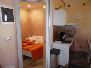 ein kleines Schlafzimmer mit einem Bett und einer Küche in der Unterkunft Rifugio Storico sul Mare in Agay - Saint Raphael